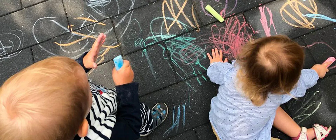 Kinder malen mit Kreide